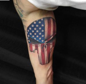american flag inside of punisher skull on man's inner bicept